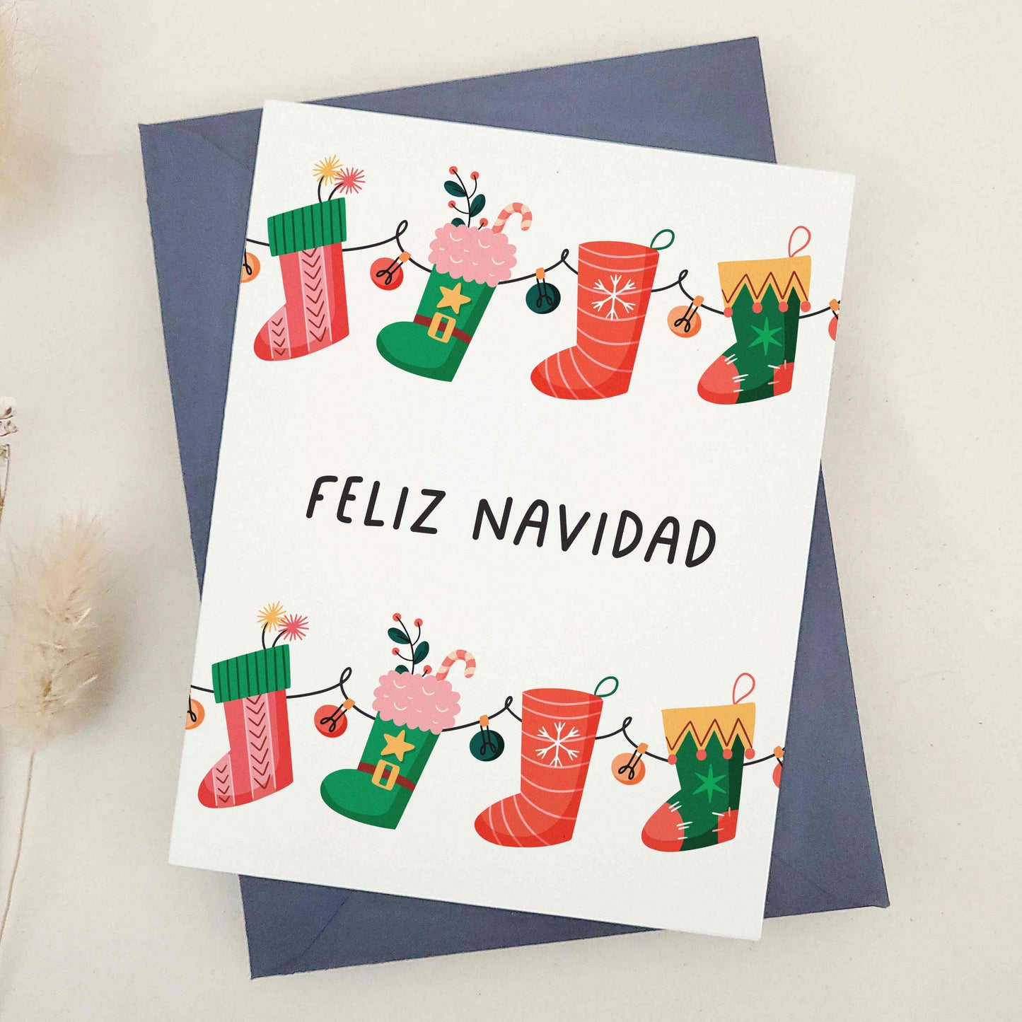 Vibrant 'Feliz Navidad' card blending festive cheer with playful charm, adorned with colorful Christmas stockings, each uniquely decorated to represent the diverse joys of the holiday season. The design captures the spirit of celebration with various patterns and colors, symbolizing the richness of holiday traditions, perfect for sharing the happiness and vibrancy of Christmas with friends and family.